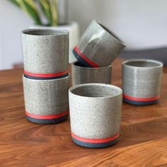 four cement cups sitting on top of a wooden table