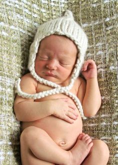 a newborn baby wearing a knitted hat