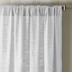 a white curtain hanging on the side of a window