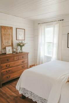 a bedroom with white walls and wood floors