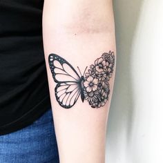 a woman's arm with a butterfly and flowers tattoo on the left side of her arm