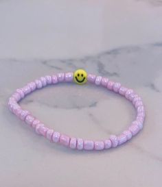 This bracelet is a great accessory to pair with anything! It could be a gift or even for yourself! The string is stretchy but not adjustable. :) Trendy Stretch Bracelet With Smiley Face Round Beads, Trendy Smiley Face Stretch Bracelet With Round Beads, Cute Adjustable Beaded Bracelets For Everyday, Casual Adjustable Smiley Face Friendship Bracelets, Casual Adjustable Smiley Face Bracelets, Casual Adjustable Smiley Face Bracelet, Adjustable Smiley Face Round Bead Bracelets, Everyday Beaded Bracelets With Smiley Face, Cheerful Adjustable Beaded Bracelets With Smiley Face