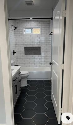 a bathroom with black and white tile flooring