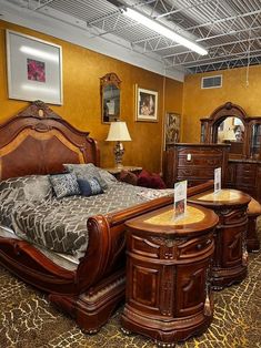 a bed room with a neatly made bed and wooden furniture