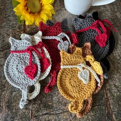 four crocheted animal purses sitting on top of a table next to a sunflower