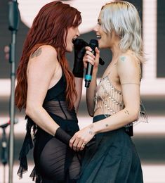 two women are talking while holding microphones