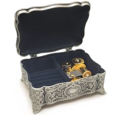 an ornate silver box with two compartments filled with small objects and some sort of watch movement