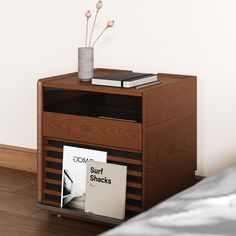 a nightstand with a magazine rack and magazines on it