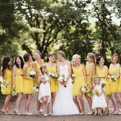 a group of women in yellow dresses standing together