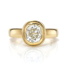 a yellow gold ring with an oval cut diamond