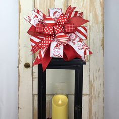 a red and white bow on top of a lantern