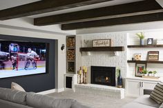 a living room filled with furniture and a flat screen tv mounted on the wall above a fire place