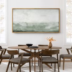 a dining room table with four chairs and a painting on the wall above it,