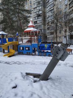 a playground in the middle of winter with snow on the ground and children's play equipment