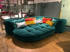 a green couch sitting on top of a hard wood floor next to a metal rack