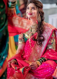 a woman sitting down wearing a red and gold outfit