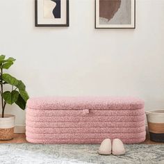 a pair of slippers sitting on top of a pink couch next to a potted plant