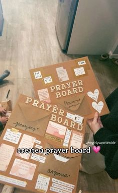 a person sitting on the floor next to a cardboard board with words written on it