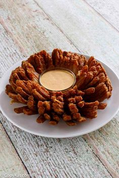 a plate that has some kind of food on it with dipping sauce in the middle