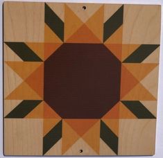 a wooden wall hanging with an orange and black design on it