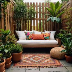 an outdoor seating area with potted plants and pillows