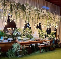 an image of a wedding reception with flowers and greenery on the wall behind it