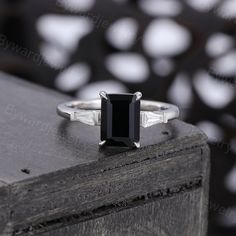 a black diamond ring sitting on top of a wooden box