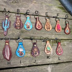 a group of different colored leather key chains on a wooden table with letters and numbers