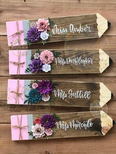 three wooden signs with flowers and ribbons on them