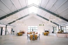 a large room with tables, chairs and chandeliers