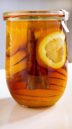 a glass jar filled with orange slices and cinnamon sticks