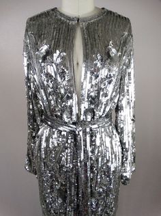 "This is another AMAZING vintage piece! It's fully embellished with eye-catching reflective sequins and is in perfect condition! Measurements: Bust - 40\" Shoulders - 16\" Sleeves - 21\" Top to Bottom - 31\" All of my items come from a smoke-free and pet-free home. If you have any questions, please don't hesitate to ask!" Fitted Silver Sequined Outerwear, Glamorous Sequined Evening Outerwear, Glamorous Sequin Outerwear For Evening, Glamorous Embellished Outerwear For Party, Glamorous Embellished Party Outerwear, Silver Sequined Evening Outerwear, Silver Sequined Outerwear For Evening, Glamorous Embellished Metallic Sequin Fabric, Glamorous Embellished Outerwear For Festive Occasions