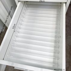 the bottom shelf of a white cabinet is shown with measurements