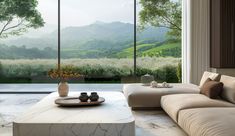 a living room filled with furniture and a large window overlooking the mountains in the distance