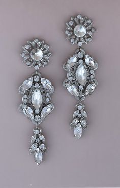 The beautiful MARLEE IKON Earrings with Swarovski and Cubic Zirconia Crystals are Absolutely Precious. They are classic and whimsical to give you that Radiant look that can be worn for any occasion. The design is made up of round crystals with a bold style. They can be styled with most of our wedding headpieces and Bridal Tiaras and Crowns for a gorgeous and statement look. Handcrafted Unique Design Highest Quality & Finest Materials Brilliant SWAROVSKI Crystals Cubic Zirconia Rhodium / Platinum Crystals Wedding, Bridal Tiaras, Wedding Headpieces, Special Occasion Jewelry, Boutique Couture, Free Earrings, Bold Style, Swarovski Crystal Earrings, Headpiece Wedding