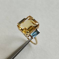 ITEM DESCRIPTION: >> The Ring is made from Solid 14K Yellow Gold. Gemstone used is absolutely natural and ethically sourced. >> Natural Citrine and London Blue Topaz in prong setting is studded on it with utmost precision. >>Center Gem: Citrine Center Gem size: 12x10 mm Center Gem weight: 5.55 ct >>Side gemstone: London Blue Topaz Side Gems size: 6x3 mm Gem weight: 0.90 carats Gold purity: 14K (58.33% approx.) Gold weight: 0.95 grams Total Gemstone weight: 6.45 carats Gross weight : 3.54 grams T Yellow Topaz Ring, Contemporary Jewelry Design, Smoky Quartz Ring, Topaz Engagement Ring, London Blue Topaz Ring, Sky Blue Topaz, Citrine Ring, Natural Citrine, December Birthstone