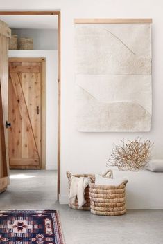 a room with a rug, basket and wooden door