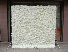 a large white flower covered wall in front of a building