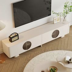 a flat screen tv mounted to the side of a white entertainment center in a living room