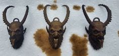 three wall mounted animal heads with long horns on top of a white cloth covered table