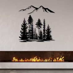 a fireplace with a fire in it and some mountains on the wall behind it,