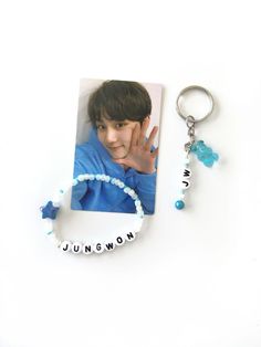 a key chain with a photo on it next to a beaded bracelet that reads, i love you