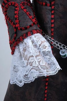 a close up of a woman's shirt with chains attached to the collar and cuffs