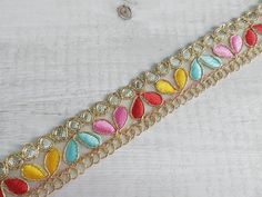 a gold chain with multicolored stones on it