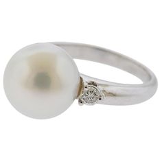 18 white gold cocktail ring, set with 12.2mm South Sea pearl and two diamonds (approx. 0.24ctw). Ring size 6.5. Marked 750. Weight 8.3 grams. Luxury White Pearl Gemstone Ring, Filigree Ring Gold, Diamond Gold Ring, Pearl And Diamond Ring, Platinum Diamond Rings, Rose Gold Studs, Gold Cocktail Ring, Contemporary Ring, Colorless Diamond