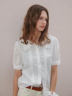 This is a casual and comfortable blouse that is made out of high quality cotton and rayon blend fabric. With design detail of embroidered lace detail on the collar and sleeve, it gives a trendy and casual look. - Rose label detail- Voluminous silhouette with shirring on shoulder and sleeve- Embroidered lace detail on collar and sleeve White Cotton Doll Collar Shirt, White Cotton Shirt With Doll Collar, Casual White Blouse With Lace Cuffs, Chic Cotton Lace Top With Lace Collar, Elegant White Cotton Lace Top, White Tops With Detachable Collar For Workwear, Casual Fitted Blouse With Lace Cuffs, White Top With Detachable Collar For Work, White Top With Detachable Collar For Workwear