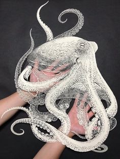 an octopus mask is being held by someone's hand with the tentacles attached to it