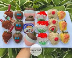 a table topped with lots of fake strawberries and chocolate covered strawberries on top of each other