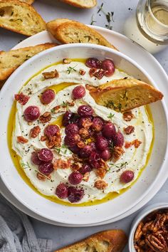 a white bowl filled with hummus, olives and bread