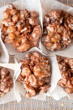 four cookies are covered in caramel glaze on top of white paper wrappers